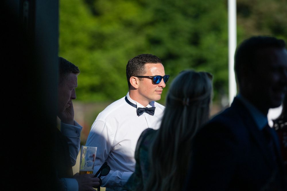 Outdoor event gathering with guests in formal attire.