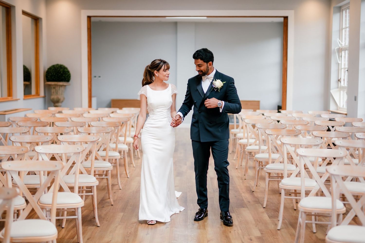 First look in British wedding outfits — bride in Pronovias gown, groom in tuxedo, fusion wedding photography