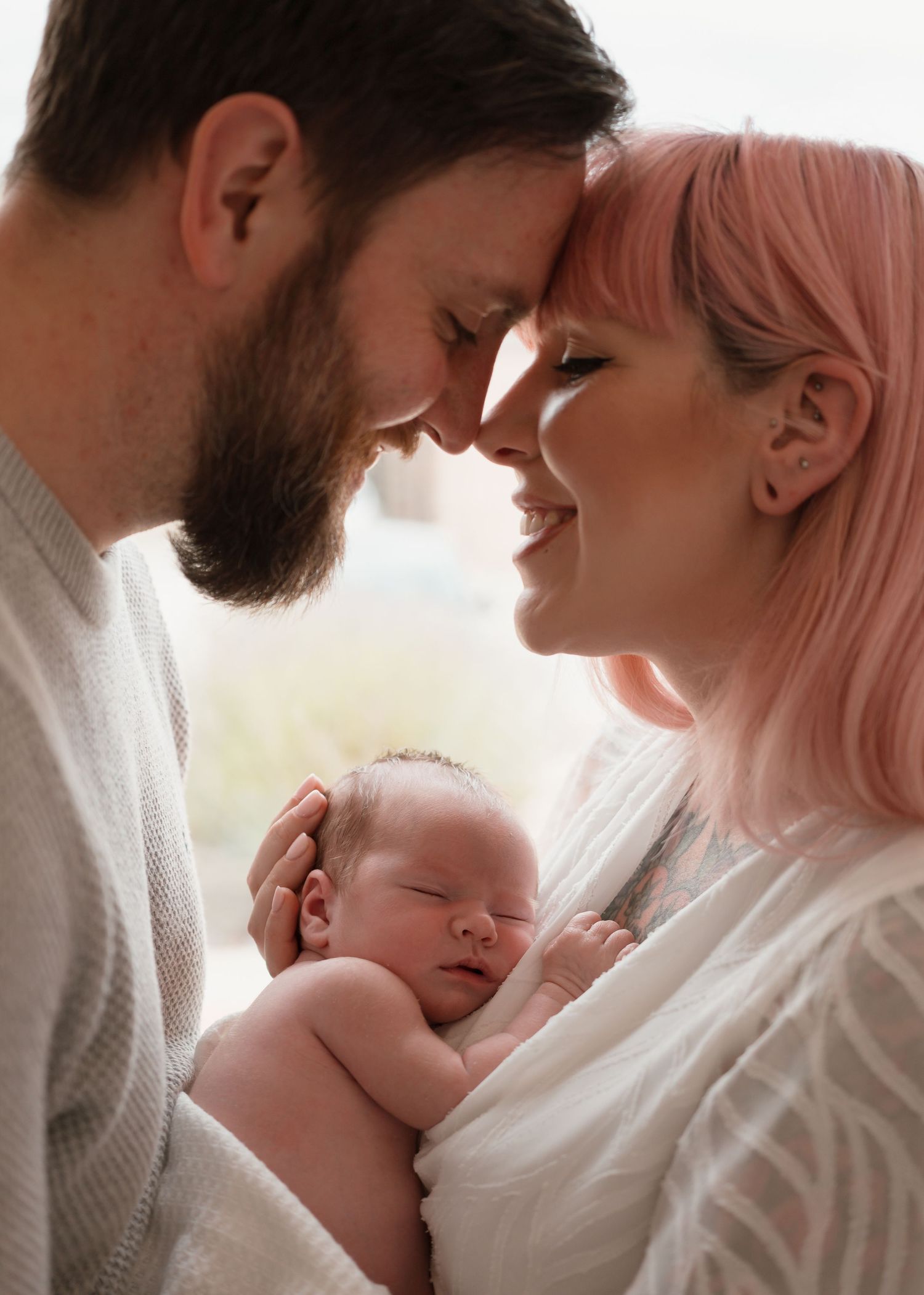 Newborn Photography - tender family moment shows parents cradling with their sleeping newborn baby in a series of intimate photos.