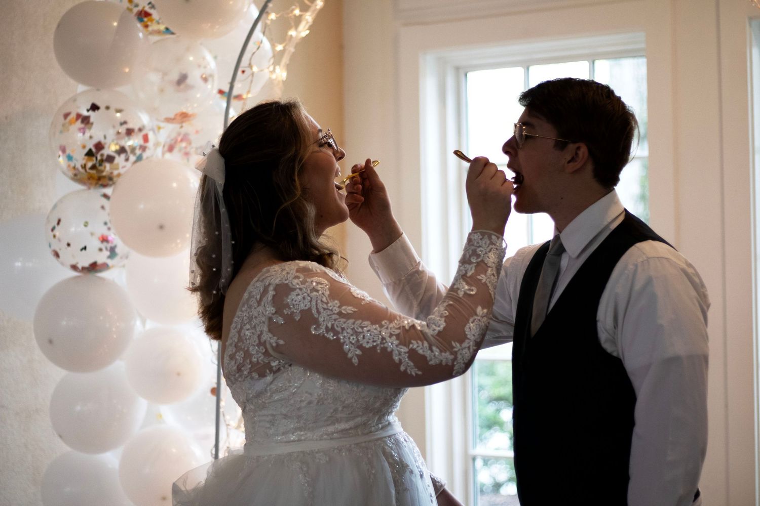 Wedding couple toasting with champagne flutes in an elegant indoor setting.
