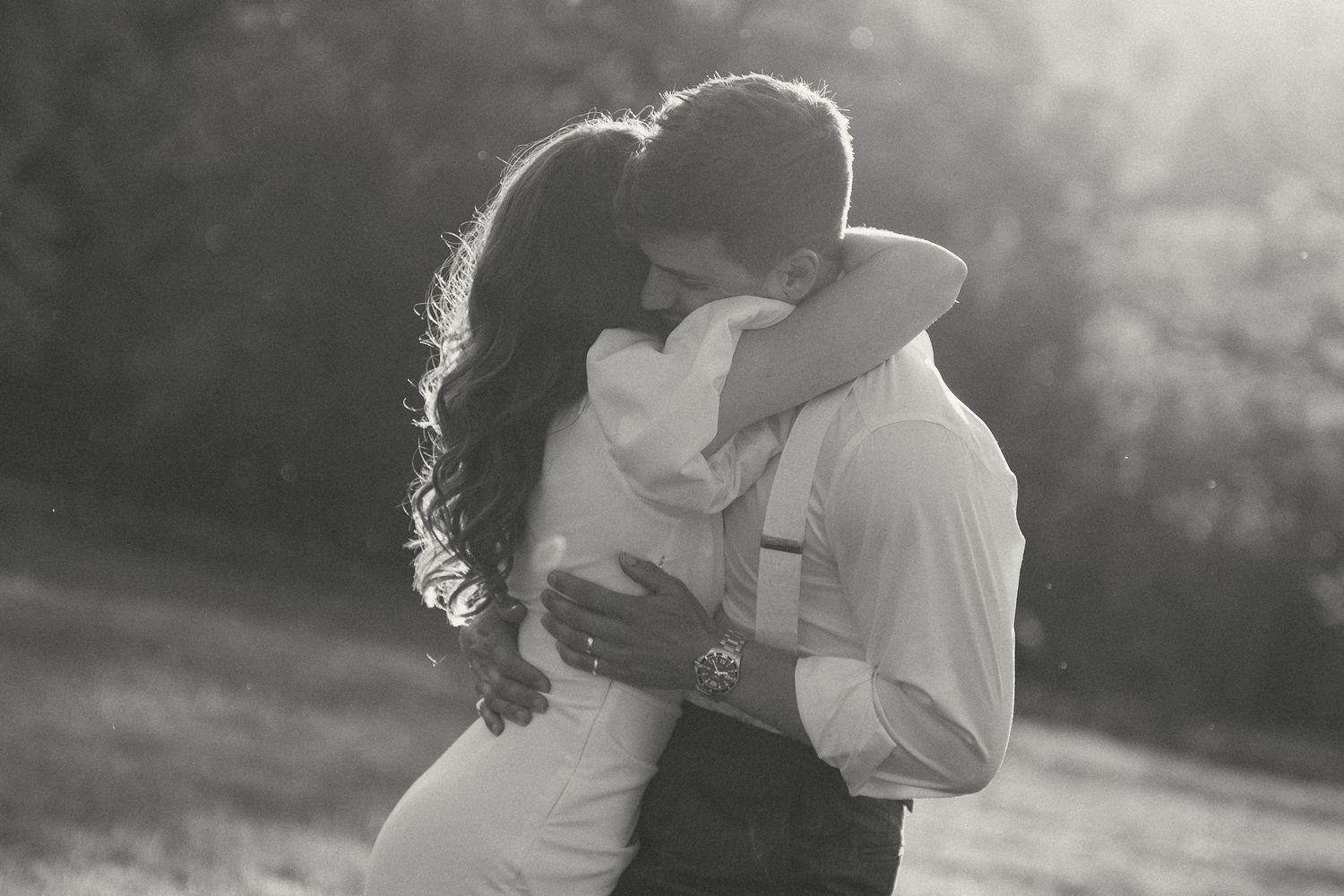 A romantic black and white photo sequence shows a couple embracing and kissing in a sunlit outdoor setting.