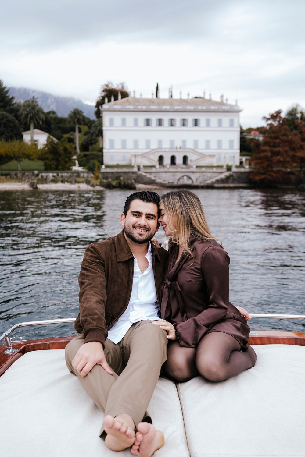 A romantic boat ride along a lake with a white mansion visible in the background near the water's edge.