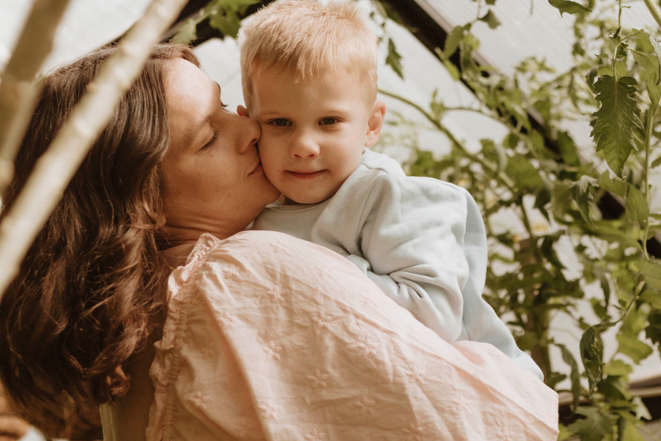 A tender moment captured between parent and child amongst tree branches.
