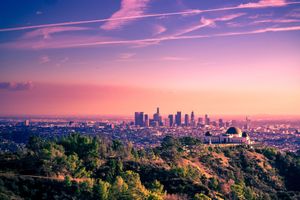 Los Angeles cityscape panorama at sunset with pink and purple skies glowing above the urban skyline.