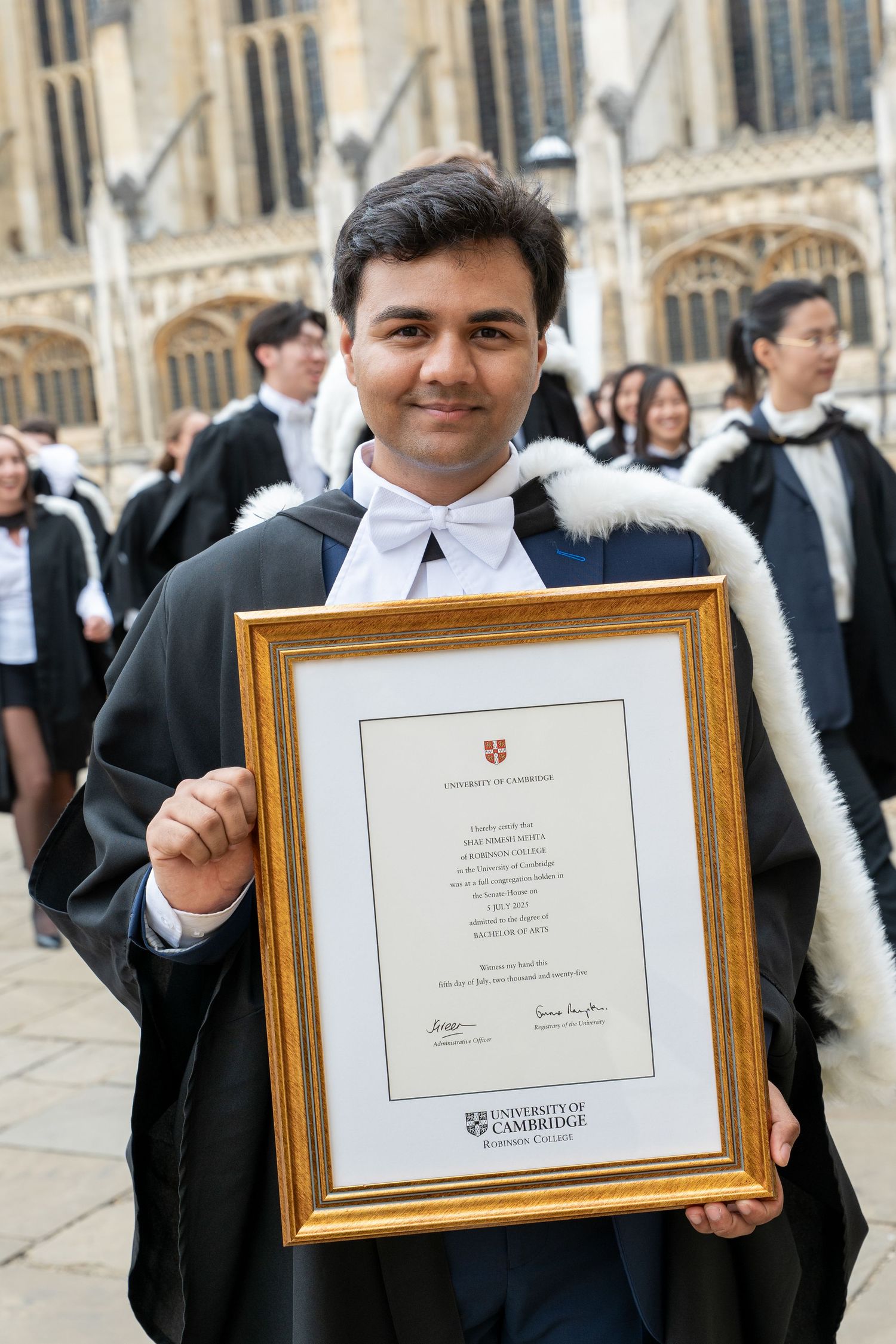 Graduates display their framed academic diplomas during a university commencement ceremony.
