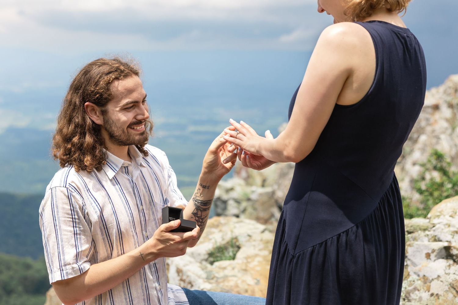 A couple gets engaged during a scenic mountain overlook proposal, with multiple images showing the special moment.