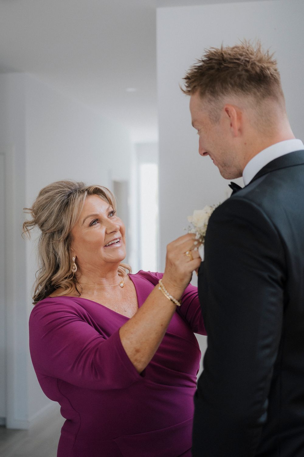 Wedding couple shares joyful moment in bright indoor setting with modern decor.