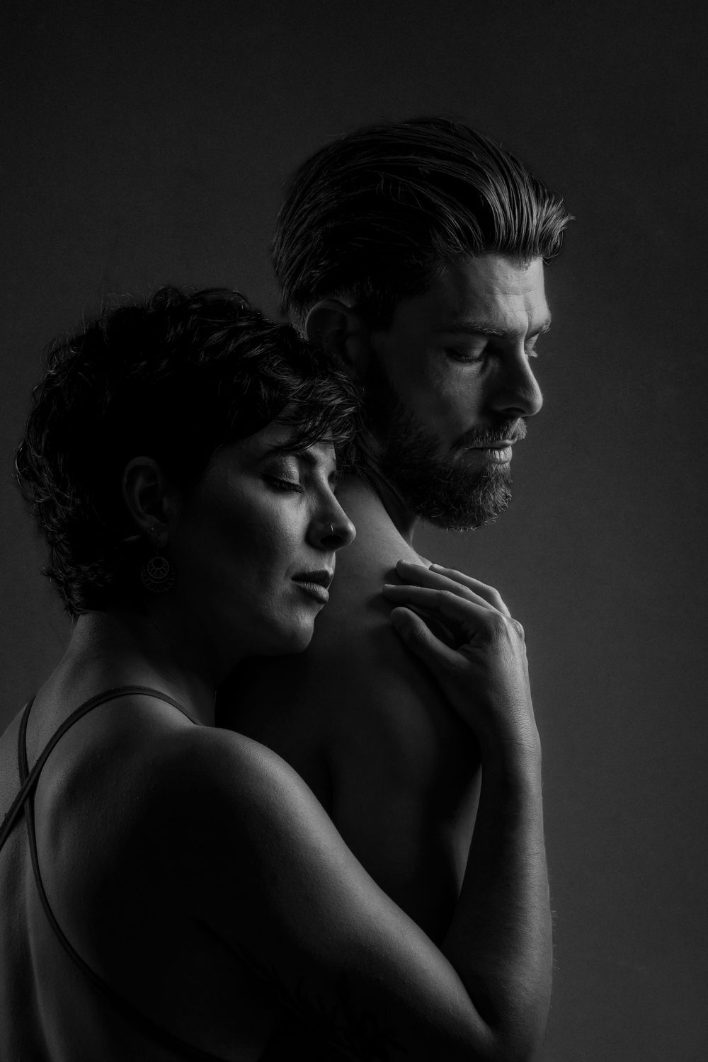A dramatic black and white series of intimate portraits showing artistic silhouettes in moody lighting.
