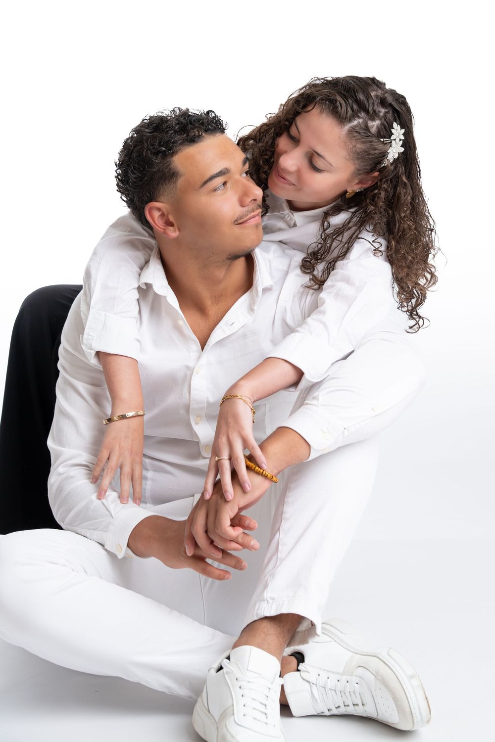 Intimate fashion photography series with models in white clothing on light background.