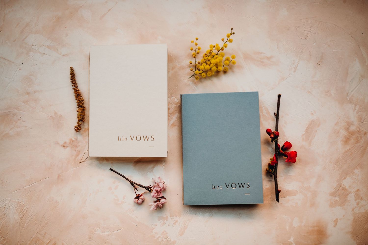 Elegant blush pink and grey stationery pieces with golden mimosa flowers arranged on textured background.