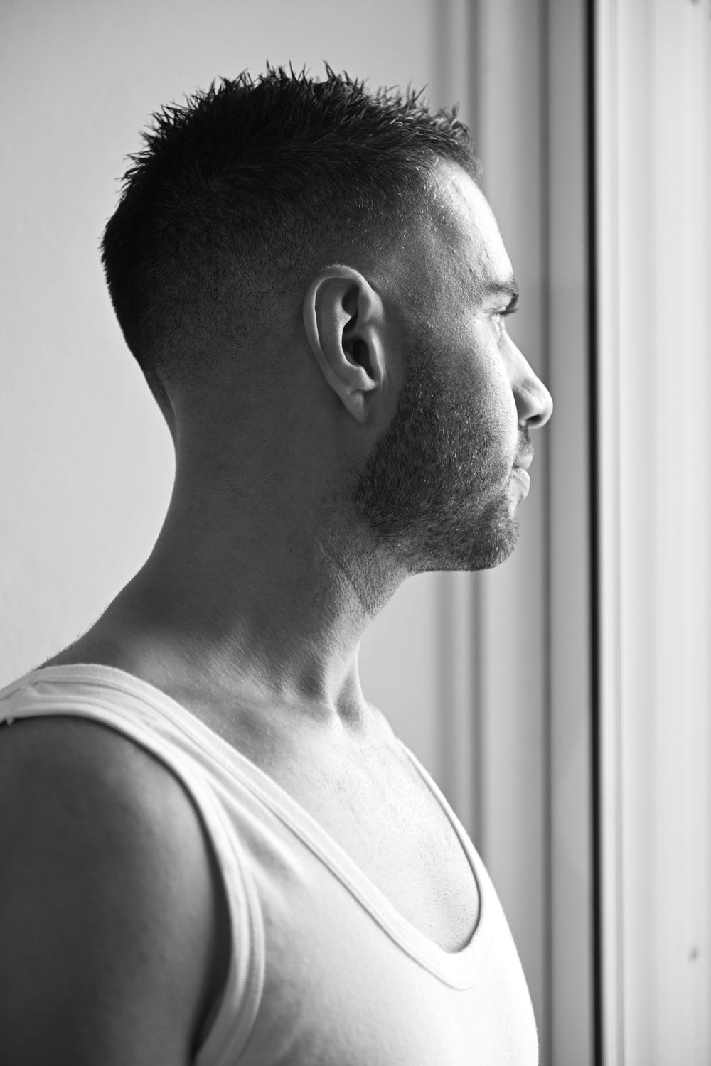 Side profile portrait in black and white showing short hair and beard style.
