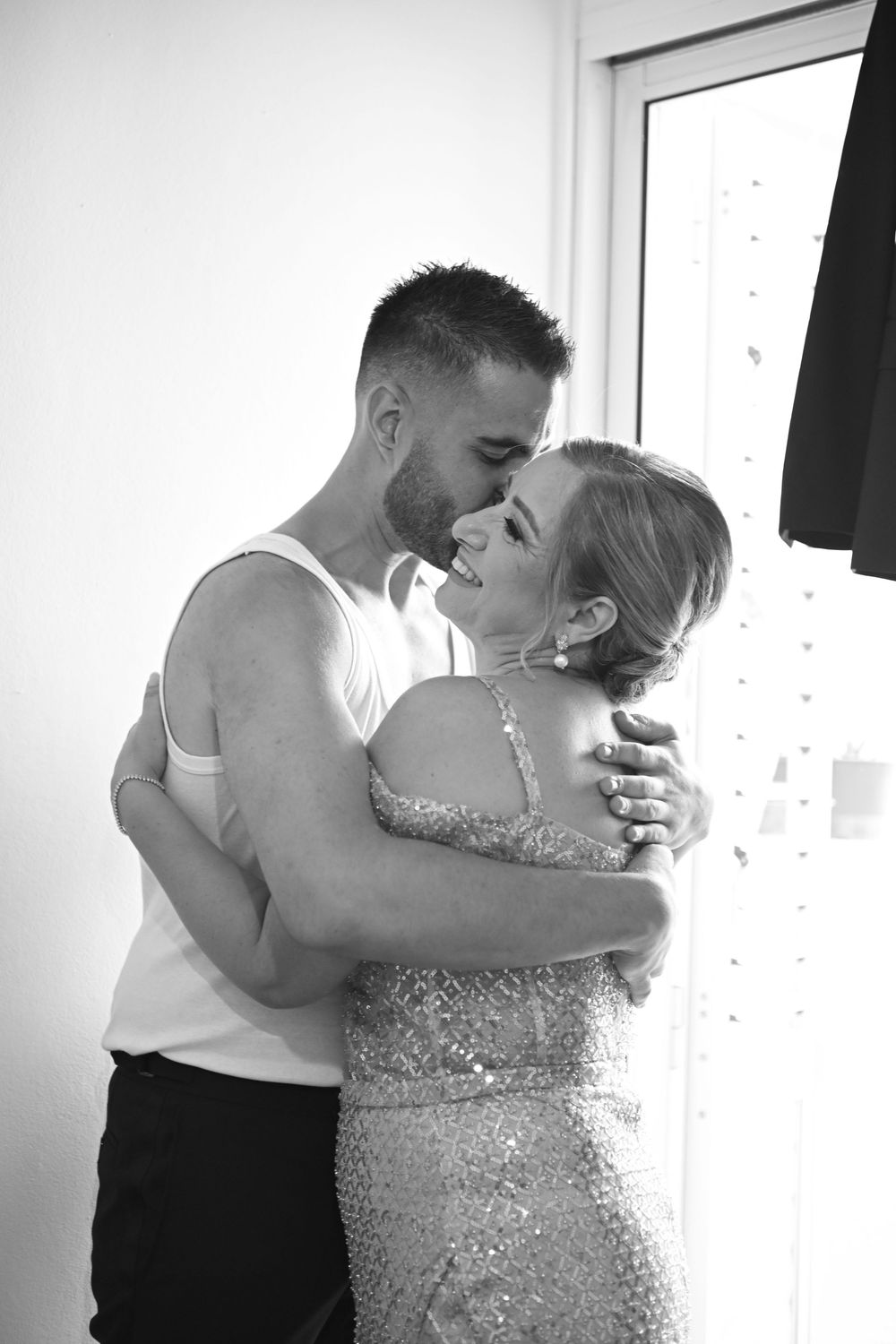 Romantic black and white photo of couple embracing in formal attire.