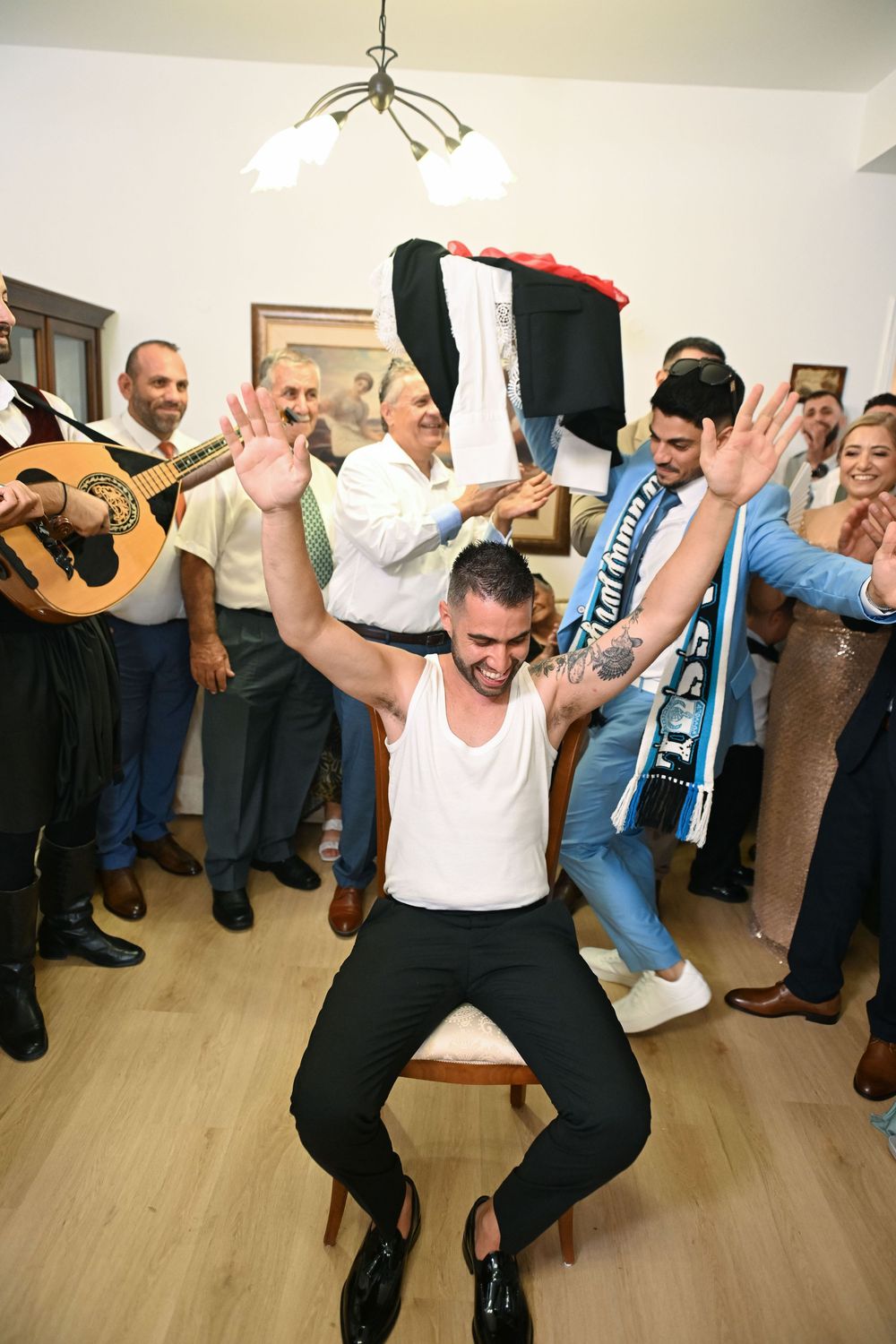 Wedding celebration scene with guitar player and guests cheering.