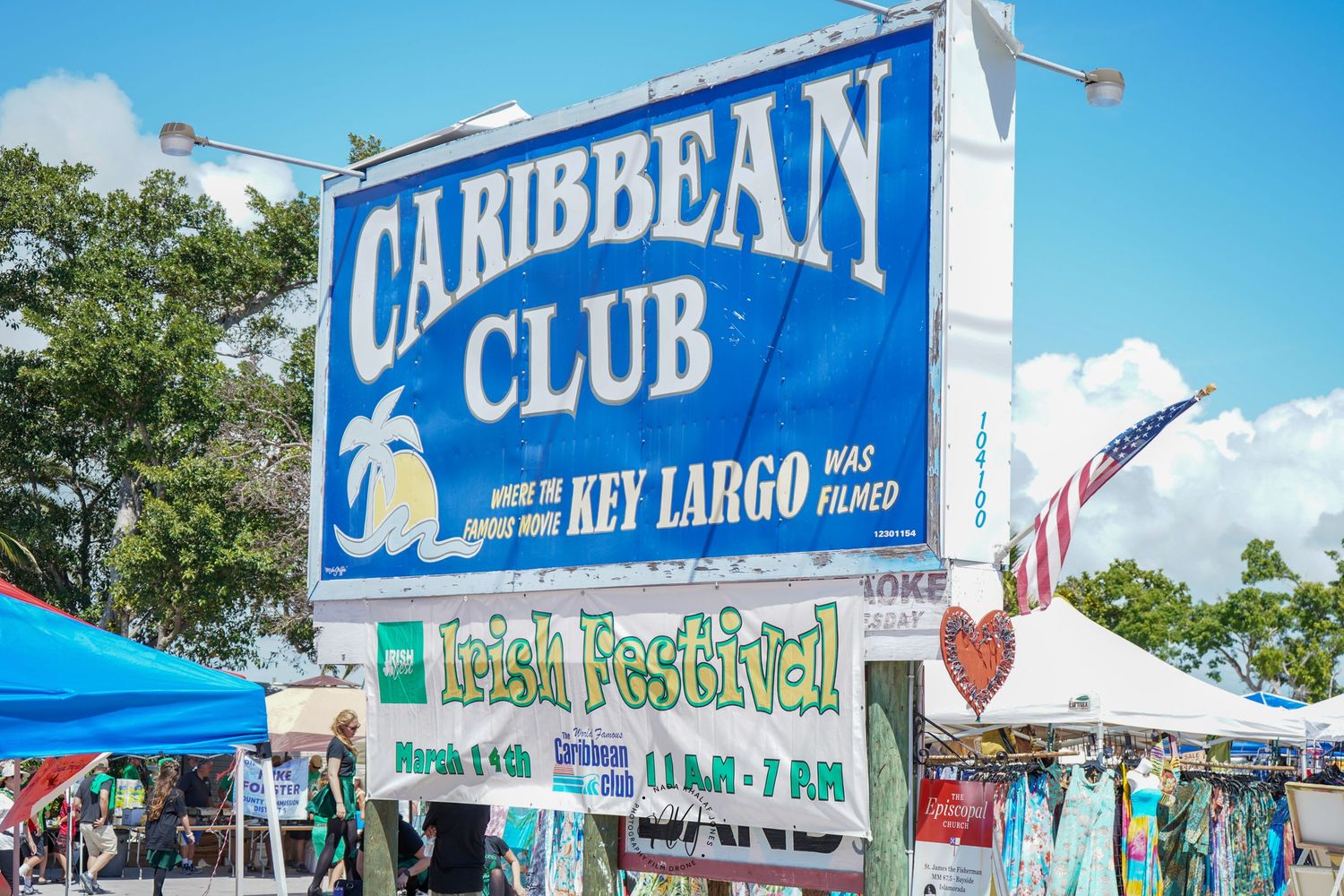 Caribbean Club outdoor sign and event tents at Key Largo, Florida with blue sky backdrop.