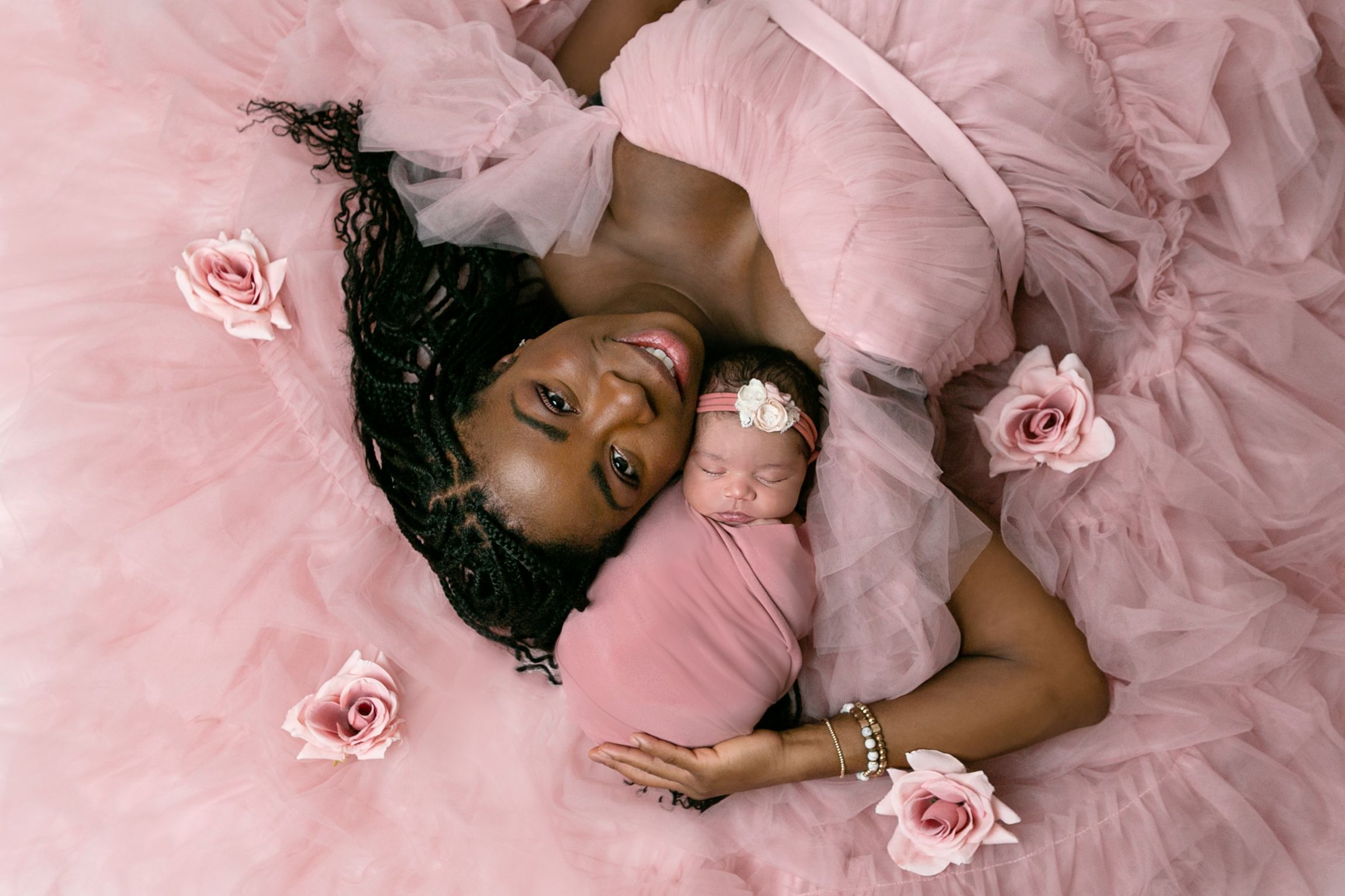 Orlando FL Maternity Photography 21 Moments Photography new mom in pink ruffle dress laying down holding her baby girl