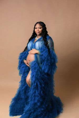 Orlando FL Maternity Photography 21 Moments Photography pregnant lady holding her baby bump wearing blue ruffle robe