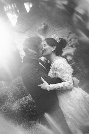 A romantic series of wedding photos showing a couple embracing in ethereal black and white lighting.