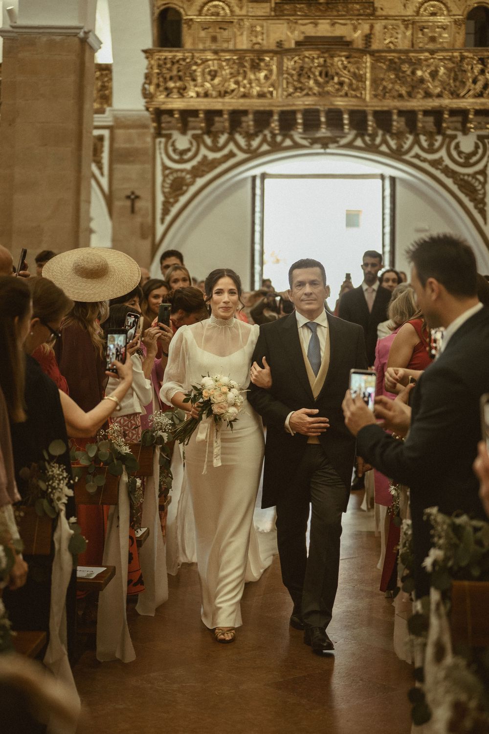 A series of five consecutive wedding reception photos showing a couple walking through a grand arched hallway with guests.