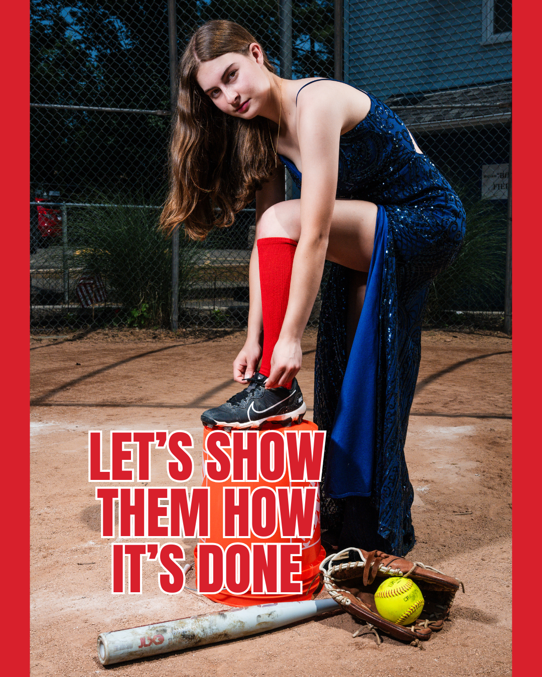 Athlete in sparkly blue dress poses with baseball bat and glove on dirt field.