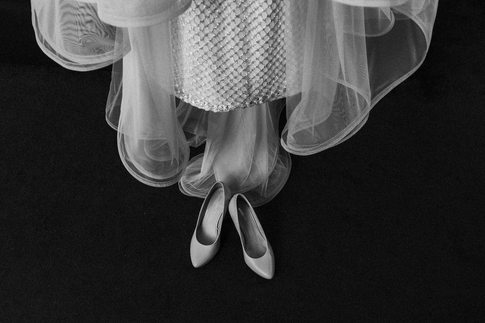 Close up of flowing white tulle wedding dress fabric against dark background.