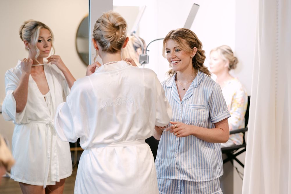 A group in white outfits dances joyfully together in an indoor setting.