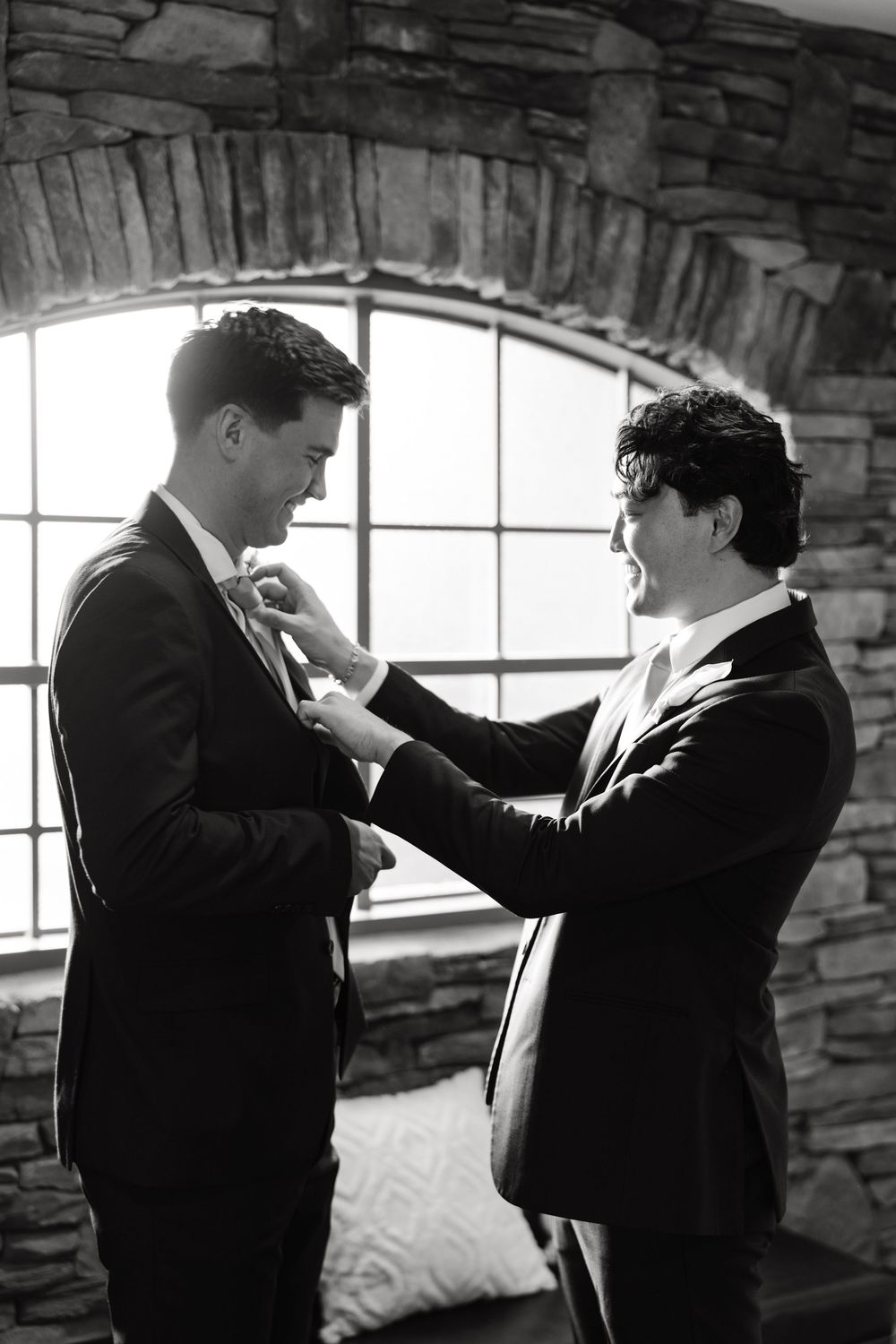 Black and white sequence showing groomsmen helping each other get ready before the wedding.