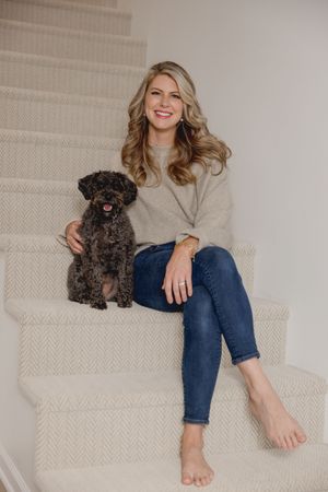 Person lounging on textured couch with small black dog in casual home setting.