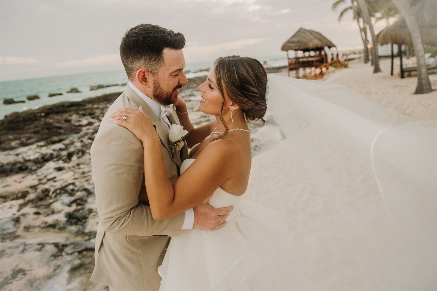 A romantic beach wedding photo series showing couples embracing on a tropical shoreline at sunset. El Dorado Royale Wedding Photographer