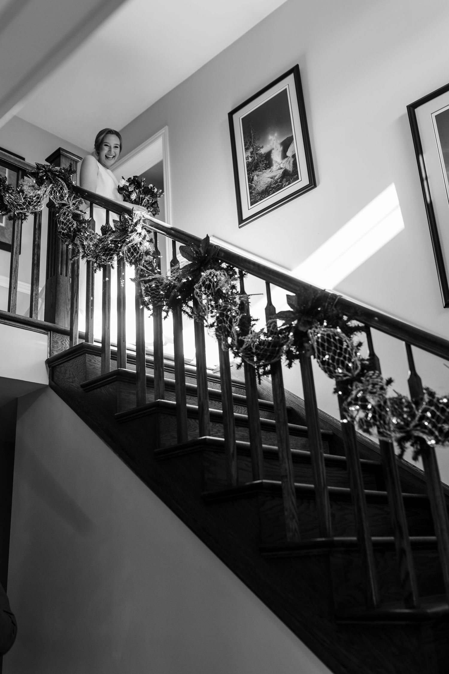 A sequence of black and white photos shows movement down a wooden staircase decorated with garland.