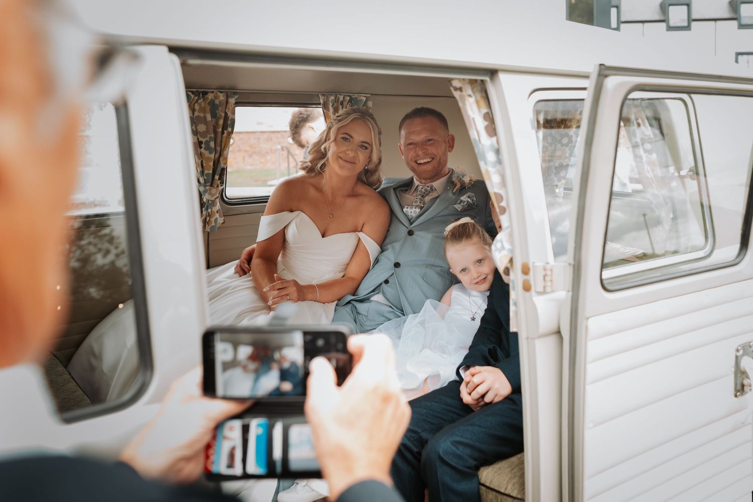 Couple shares intimate moments together inside vintage white Volkswagen van during wedding photoshoot.