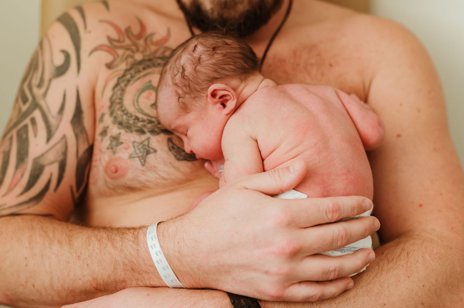 A close-up series of a father having skin to skin moments with a newborn baby