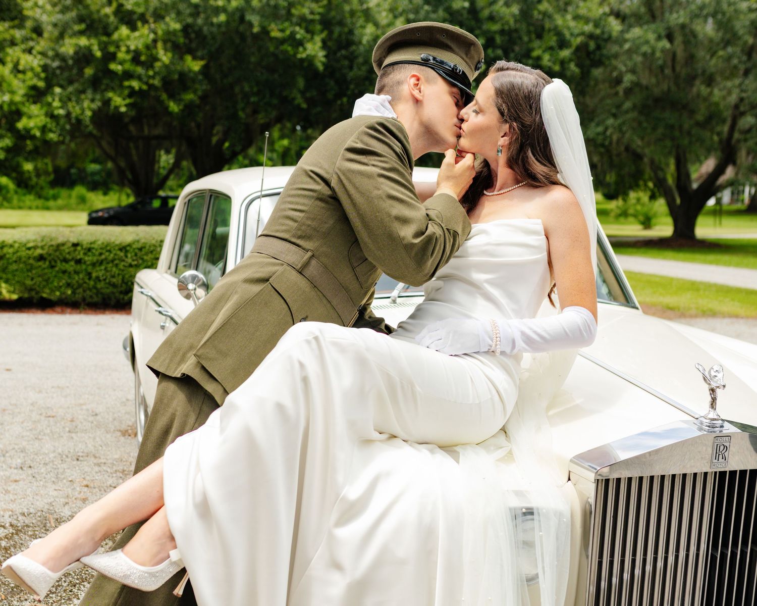 Classic wedding portrait with vintage Rolls Royce in garden setting.