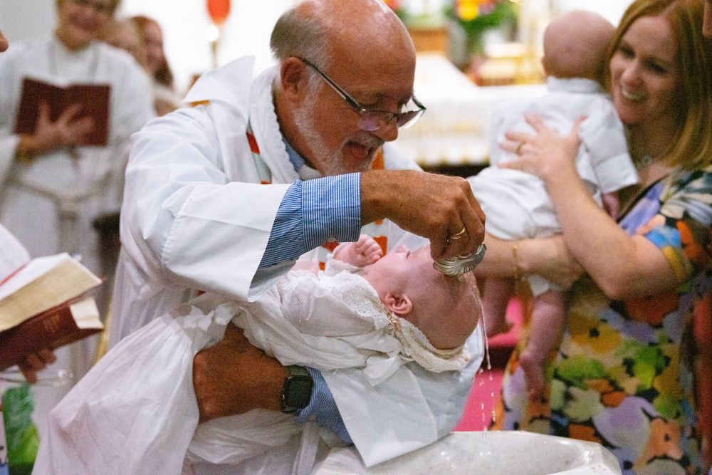 Pastor baptising baby at event session.
