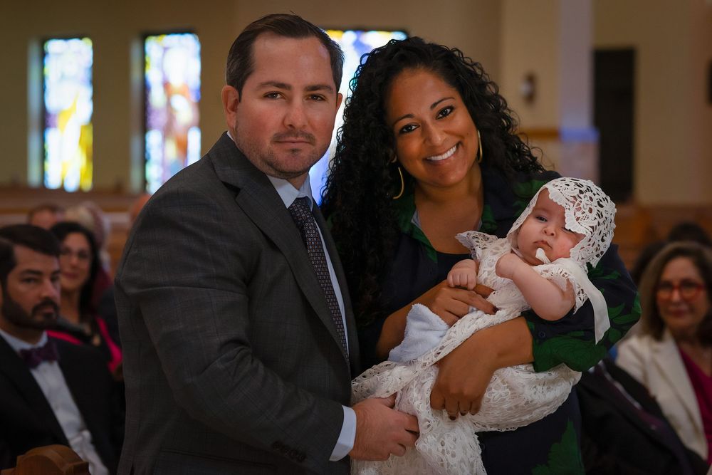 Posed shot of parents and child at a baptism event.