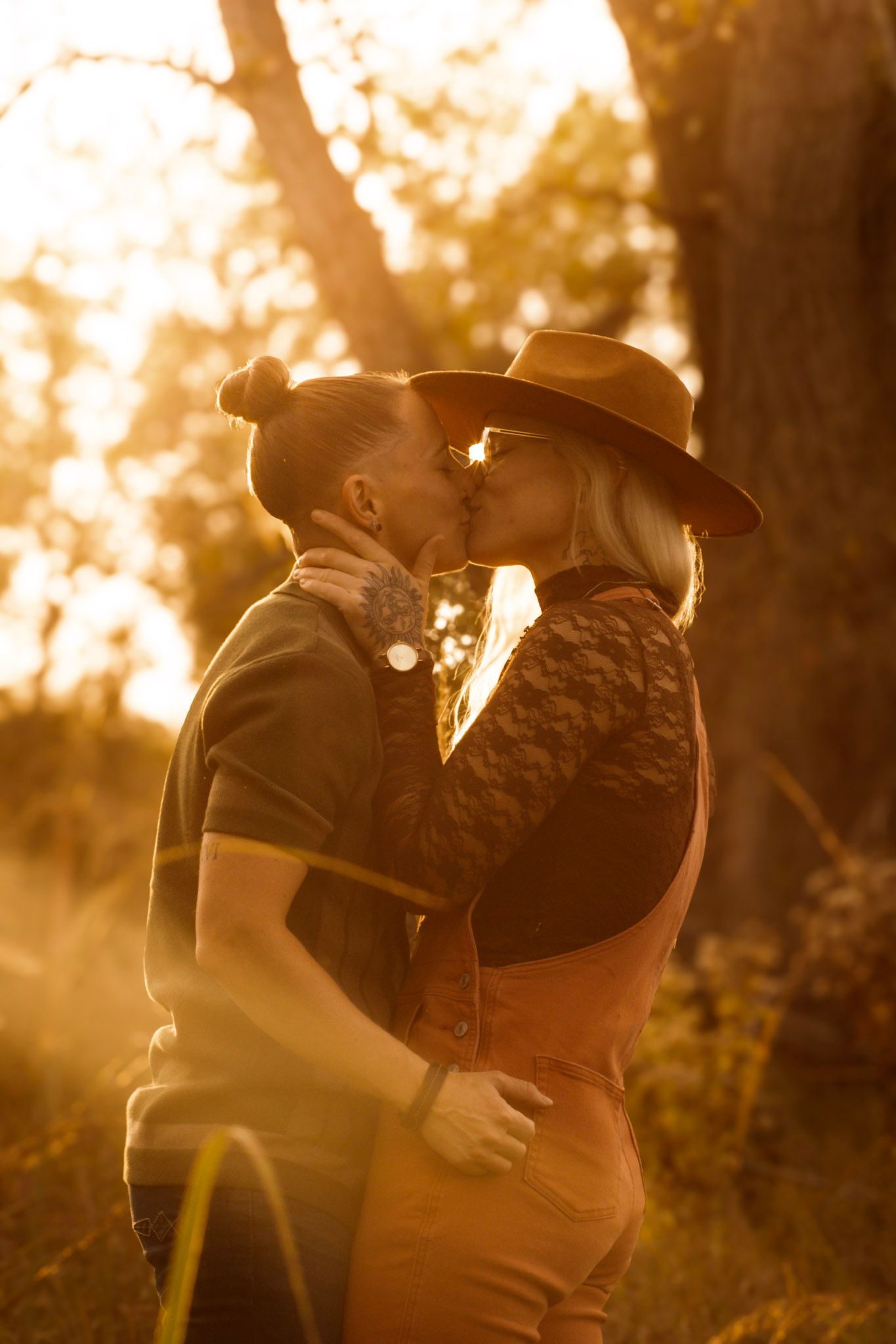 Romantic couple embracing during golden hour in a forest setting.