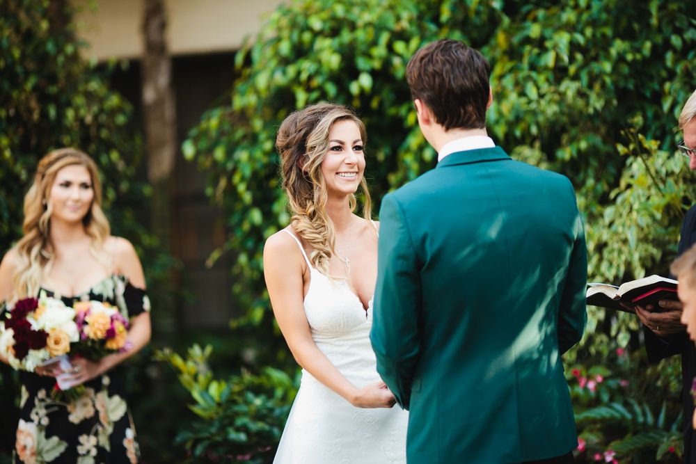 Couple shares intimate first look moment in lush garden setting during wedding ceremony.