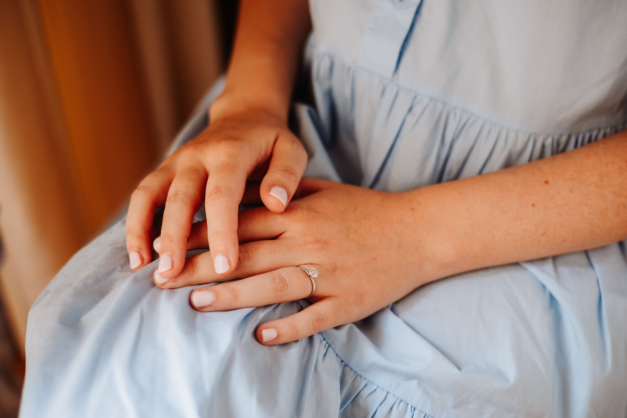 Close-up shots of hands gently resting on light blue fabric in sequence.