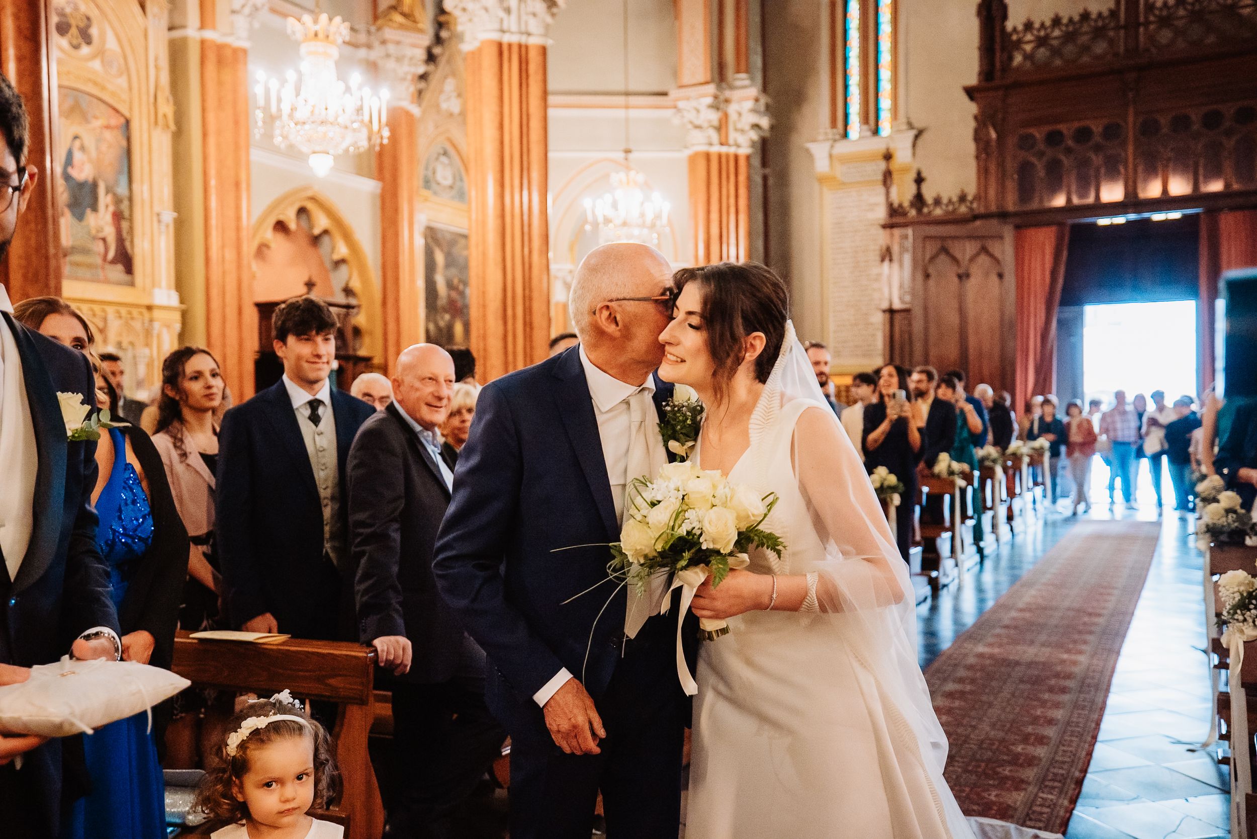 Wedding ceremony taking place in an ornate cathedral with Gothic architecture and warm lighting.