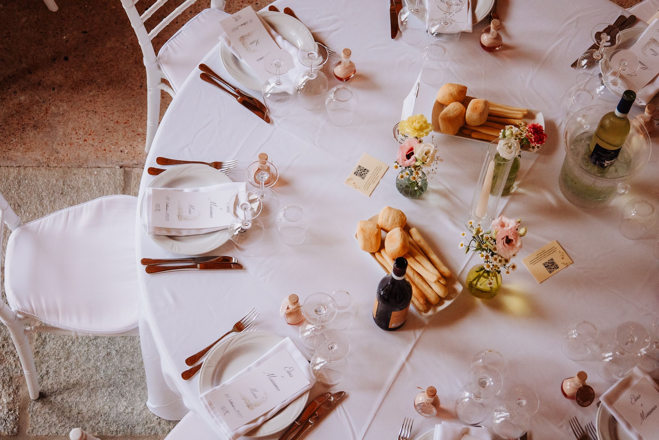 A collection of cinnamon sticks and delicate white flowers arranged on a rustic surface with soft lighting.