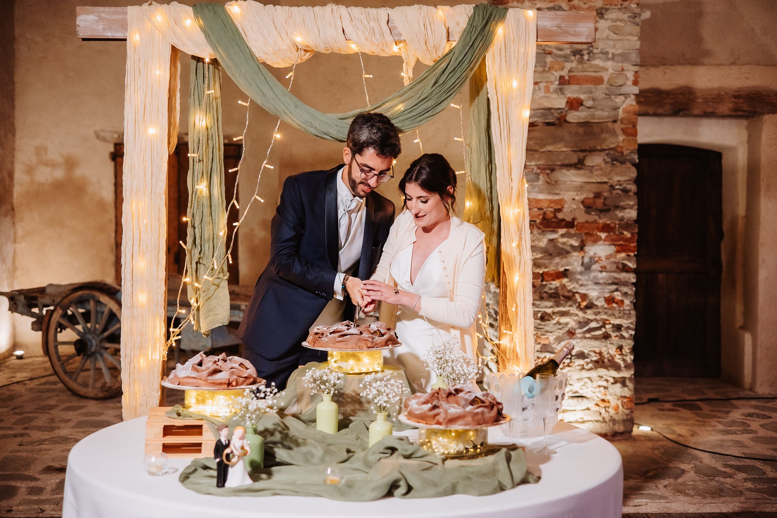 A romantic wedding reception dinner scene with elegant table settings and exposed brick walls in a rustic venue.
