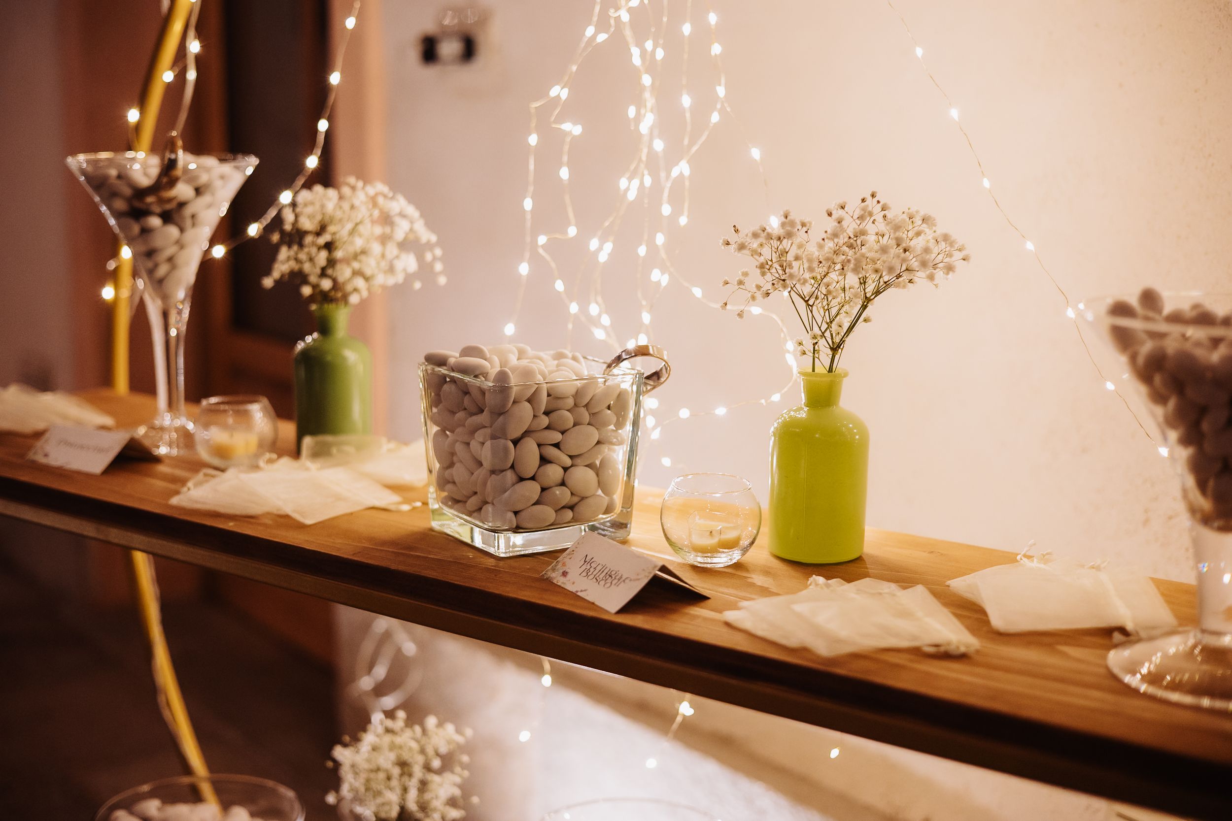 String lights and delicate floral arrangements create a romantic ambiance at a rustic wedding reception.