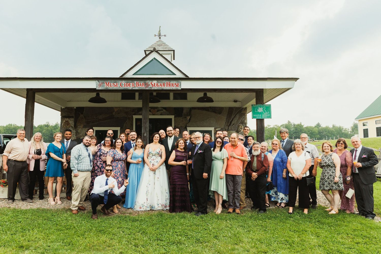 Large group gathered outside a white pavilion-style building for an event.