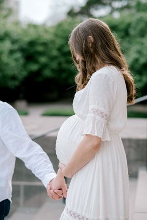 A series of romantic photos showing a couple in white clothing holding hands in a garden setting.
