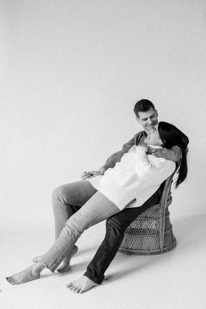 A sequence of three black and white photos showing a person lounging and shifting positions in a wicker chair.