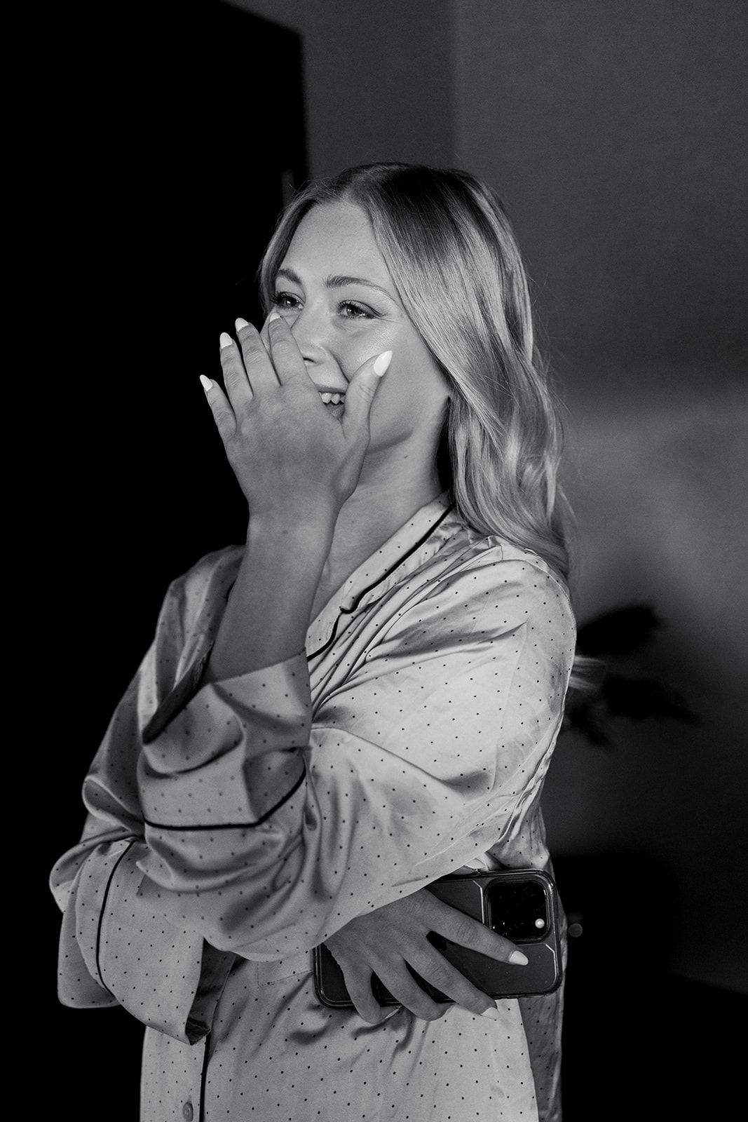 A sequence of black and white photos showing someone in a polka dot shirt covering their face with their hands.