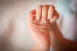 Bebeluș care se ține cu mâna de picior lifestyle acasă