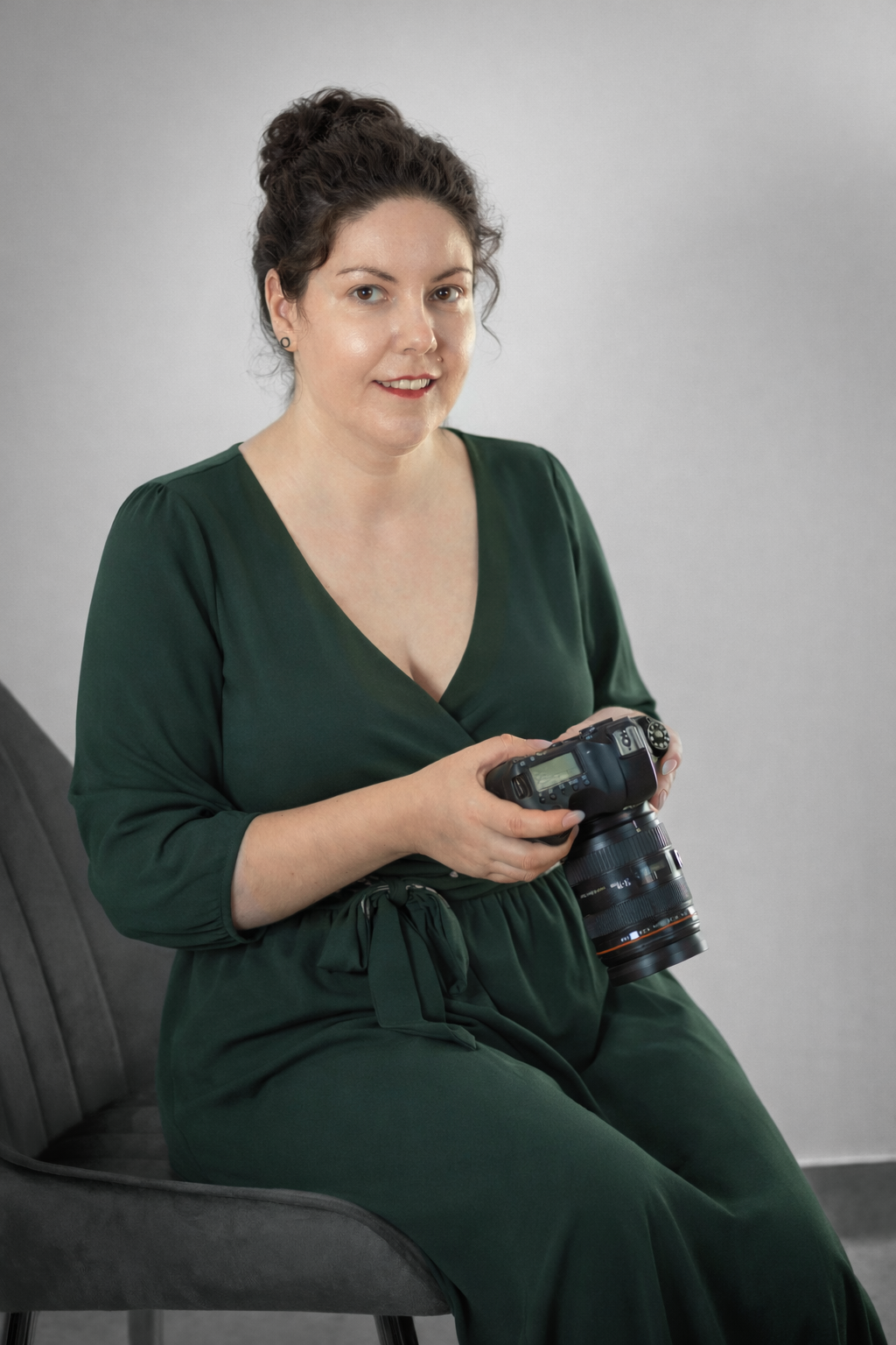 Laura Alexandru fotograf de brand stand pe un scaun cu camera foto in mana