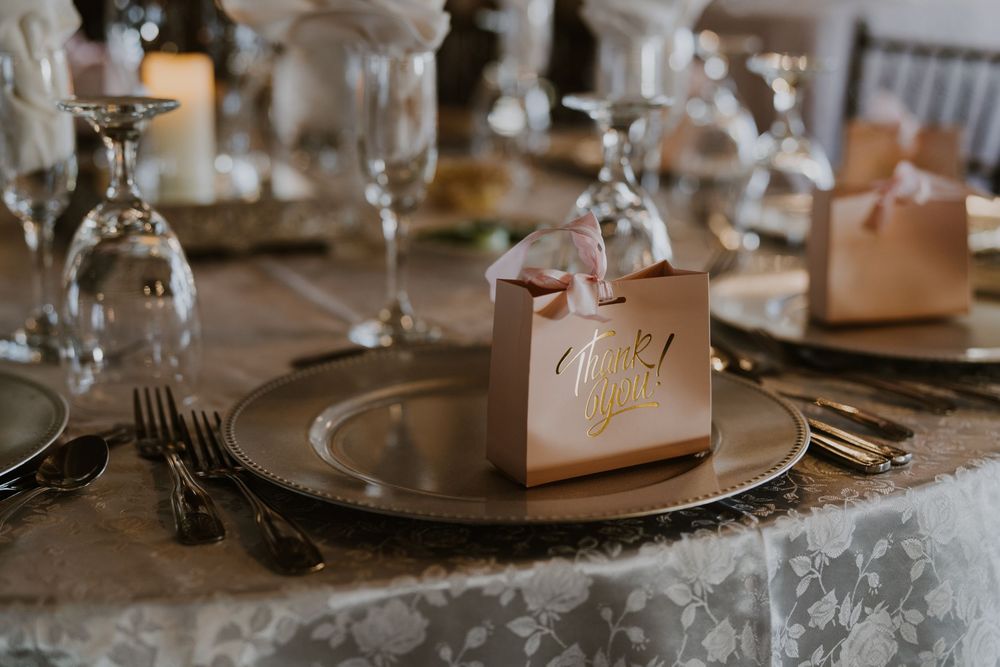 Elegant wedding reception table setting with place cards and crystal glasses.