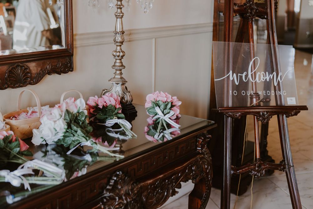 Wedding reception decor featuring crystal chandeliers and floral arrangements in a classic venue.