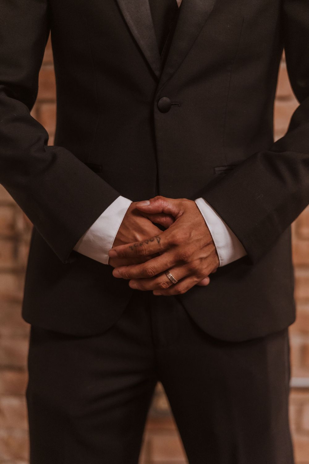 Detail shots of groom's hands and formal black suit.